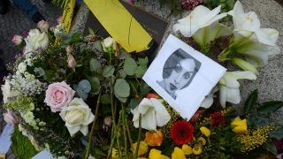 In Gedenken an die ermordete Hatun Sürücü liegen ein Foto von ihr und Blumen an einem Gedenkstein für sie. (Archivbild)