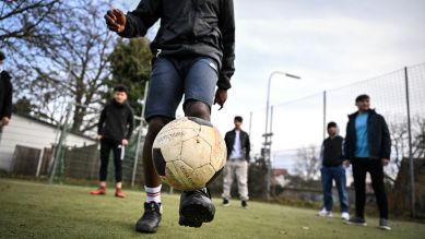 Ein jugendlicher Flüchtling aus Burundi spielt auf dem Bolzplatz im Familienferiendorf Fußball © picture alliance/dpa | Felix Kästle