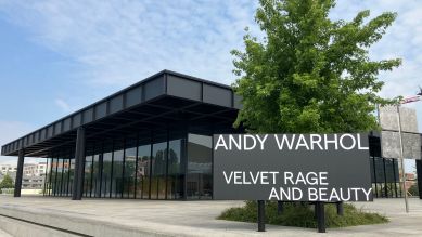 Vor der Neuen Nationalgalerie in Berlin weist ein Schild auf die Ausstellung Andy Warhol. Velvet Rage and Beauty hin. © picture alliance/dpa | Gerd Roth