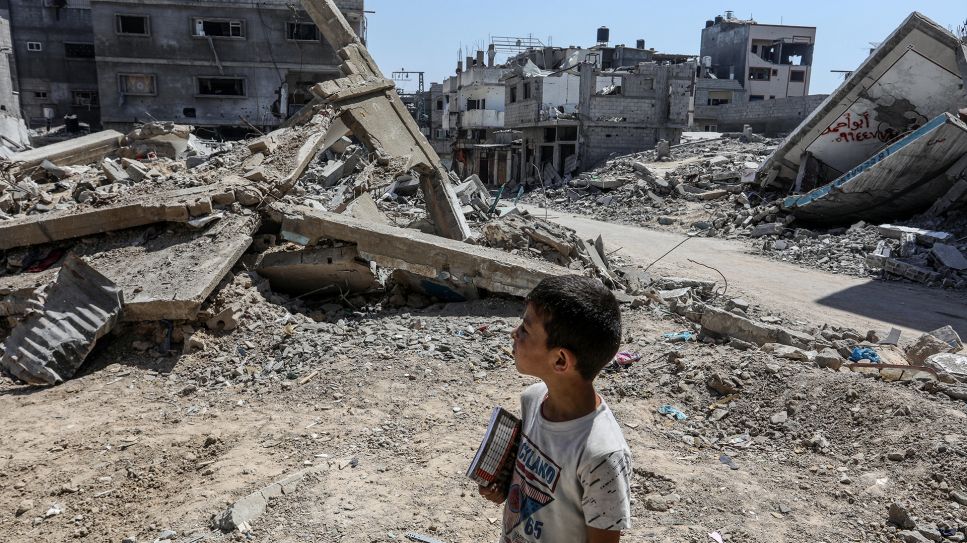 Nahostkrieg – ein Junge Blick auf ein zerstörtes Gebäude in den Trümmern von Gaza Stadt © picture alliance/ Anadolu/ Abed Rahim Khatib