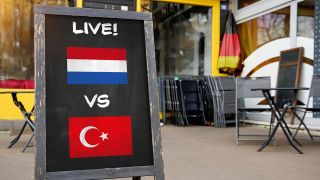 Public Viewing Niederlande vs. Türkei, eine Tafel vor einer Bar mit niederländischer und türkischer Flagge (Fotomontage) © picture alliance / CHROMORANGE | Michael Bihlmayer 