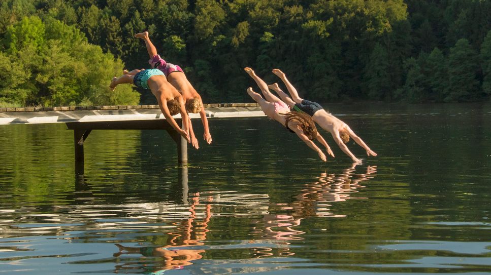 4 Menschen springen von einem Steg in einen See © picture alliance / ROHA-Fotothek Fürmann/Shotshop