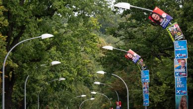 Wahlplakate der SPD, der Grünen und der AfD hängen in einem Bogen an Straßenlaternen; © picture alliance/dpa/Sebastian Gollnow