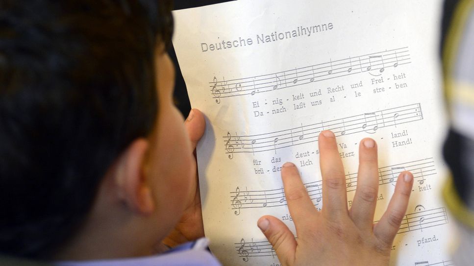 Festliche Einbürgerung im Rathaus Neukölln. Junge übt deutsche Nationalhymne. © IMAGO/ Bernd Friedel