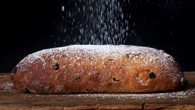 Christstollen wird mit Puderzucker bestreut; © picture alliance/Shotshop/Bernd Jürgens