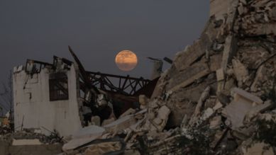 Der Vollmond geht am frühen Abend über zerstörten Gebäude im Zentrum des Gazastreifens auf. © picture alliance/dpa/APA Images via ZUMA Press Wire | Ali Hamad 