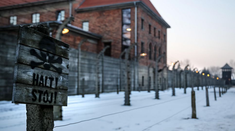 Gedenkstätte Auschwitz-Birkenau, ein Stoppschild mit einem Totenkopf vor Stacheldrahtzäunen © picture alliance/ ZUMAPRESS.com/ Dominika Zarzycka