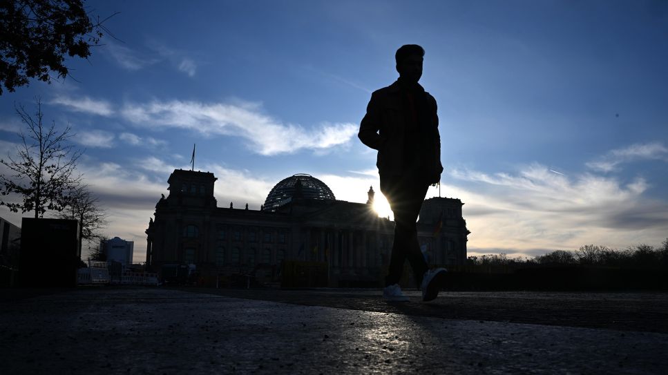 Nach der Bundestagswahl. Ein Mann geht am Morgen vor dem Reichstagsgebäude. © picture alliance/dpa/Julian Stratenschulte