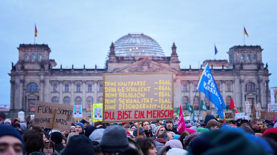 "Du. Bist. Ein. Mensch!" steht auf einem Plakat während der Demonstration "Aufstand der Anständigen – Demo für die Brandmauer" vor dem Reichstag, 02.02.2025; © picture alliance/dpa/Annette Riedl