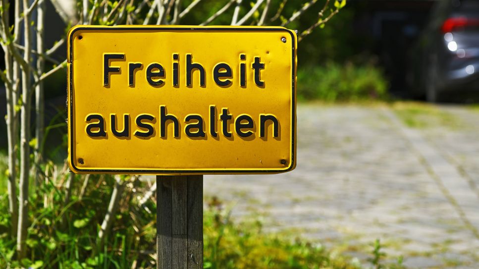 Schild mit Aufschrift Freiheit aushalten an einer Einfahrt in Hamburg; imago-images.de/Christian Ohde