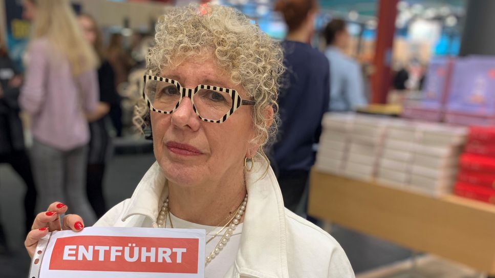 Lizzie Doronauf der Frankfurter Buchmesse mit einem roten Vermissten-Plakat © Nadine Kreuzahler